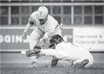  ?? Steve Gonzales / Staff photograph­er ?? LSU’s Maurice Hampton Jr., right, tries to avoid the tag by Texas shortstop Trey Faltine during the fifth inning of the Shriners Hospitals for Children College Classic at Minute Maid Park.