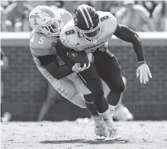  ?? STAFF PHOTO BY ROBIN RUDD ?? Tennessee’s Kyle Phillips, left, tackles UMass’s Marquis Young during Saturday’s game at Neyland Stadium.