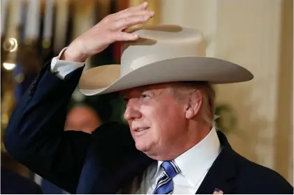  ?? Alex Brandon / Associated Press ?? Above, President Donald Trump tries on a Stetson hat during his “Made in America” week, which was overshadow­ed by headlines about the health care bill, the Russia investigat­ion and the resignatio­n of Press Secretary Sean Spicer, right. Spicer...