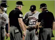  ?? JULIO CORTEZ — THE ASSOCIATED PRESS ?? Houston starting pitcher Jake Odorizzi, middle, has his belt inspected by first base umpire Ted Barrett, left, and home plate umpire Angel Hernandez during the Monday’s game.