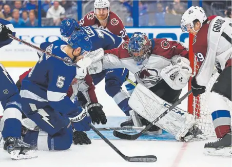  ?? Mike Ehrmann, Getty Images ?? Semyon Varlamov, who was pulled midway through the second period after allowing five goals on 23 shots, stops a shot from Tampa Bay’s Dan Girardi on Saturday night in Tampa, Fla.