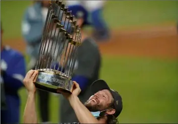  ?? AP Photo/Eric Gay ?? Los Angeles Dodgers pitcher Clayton Kershaw celebrates with the trophy after defeating the Tampa Bay Rays 3-1 to win the baseball World Series in Game 6 on Tuesday in Arlington, Texas.