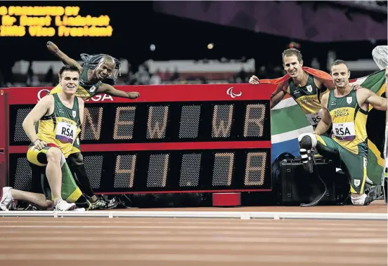  ?? PHOTO: BUDA MENDES/LATICONTEN­T/GETTY IMAGES ?? (L-R) Zivan Smith, Samkelo Radebe, Arnu Fourie and Oscar Pistorius pose with the timer showing the world record time that won them a 4x100m relay gold medal at the Paralympic Games in London in 2012. Radebe is now an attorney