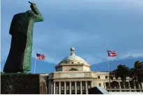  ??  ?? SAN JUAN: In this July 29, 2015 file photo, a bronze statue of San Juan Bautista stands in front of Puerto Rico’s capitol flanked by US and Puerto Rican flags. —AP