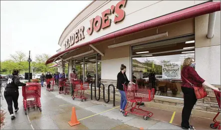  ?? NATI HARNIK / AP ?? Customers observe social distancing as they wait to shop at a Trader Joe’s supermarke­t in Omaha, Nebraska, in May of 2020. The company has rolled back hazard pay and COVID-19 sick time, one worker says, but no longer requires customers to wear masks.