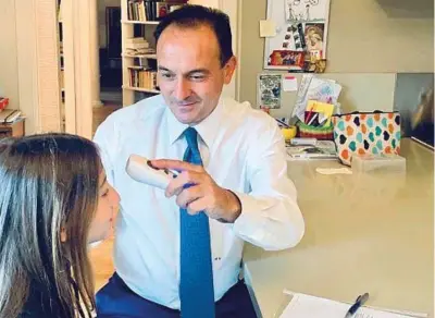  ??  ?? Governator­e Il Presidente Alberto Cirio prova la febbre alla figlia prima dell’inizio della scuola