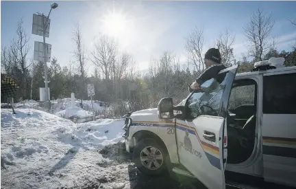  ?? PHOTOS: PIERRE OBENDRAUF ?? RCMP officer Marcel Pelletier looks over the Canadian-U.S. border on Roxham Rd. in Saint-Bernard-de-Lacolle, near Hemmingfor­d, on Thursday. The road is used by Canadian refugee claimants arriving from the American side.