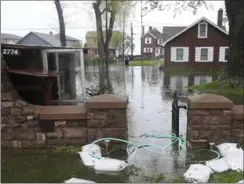  ?? JAMIE GERMANO, THE ASSOCIATED PRESS ?? Flood waters from Lake Ontario fill a yard along Edgemere Drive in Greece, N.Y., on Tuesday. “Everybody up here is upset,” said one homeowner.