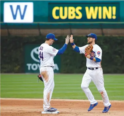  ??  ?? The Cubs’ Anthony Rizzo ( left) and Ben Zobrist celebrate the team’s 5- 0 shutout of the Cardinals on Friday at Wrigley Field. | AP