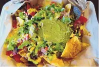  ??  ?? The Frida Pie at Tako Ten consists of tricolor tortilla chips, melted Oaxaca queso and chile topped with a generous pile of guacamole.