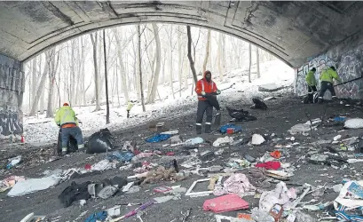 ?? RENÉ JOHNSTON TORONTO STAR ?? Toronto city workers clean the mess under a pair of Rosedale Valley bridges on Tuesday as they dismantle homeless camps.