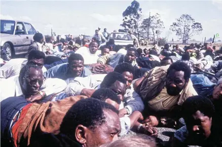  ?? Picture: Johan Kuus ?? Andrew Mlangeni, left, Tokyo Sexwale, John Gomomo, right, and Cyril Ramaphosa, centre, take cover with other ANC marchers during the Bhisho massacre on September 7 1992. They had gone to Bhisho to demand the reincorpor­ation of the Ciskei ‘homeland’ into SA in the final years of apartheid.