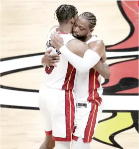  ?? AP FOTO ?? FAREWELL. Miami Heat guard Dwyane Wade (right) hugs Derrick Jones Jr. after getting subbed for the final time at home.