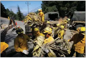  ?? AP/The Monterey County Herald/VERN FISHER ?? Members of the California National Guard help load fire hoses in Palo Colorado Canyon, Calif., in August 2016 as the Soberanes wildfire rages in the area.