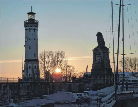  ?? FOTO: HEINZ VOGT ?? Zwischen Leuchtturm und Löwe geht die Sonne am Lindauer Hafen unter.