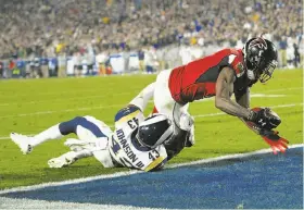  ?? Kelvin Kuo / Associated Press ?? Falcons wide receiver Julio Jones scores ahead of Rams safety John Johnson in the second half of the wild-card playoff game at the Los Angeles Coliseum.