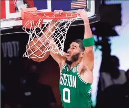  ?? Mark J. Terrill / Associated Press ?? The Celtics’ Jayson Tatum dunks the ball against the Heat during Saturday’s playoff game in Lake Buena Vista, Fla.