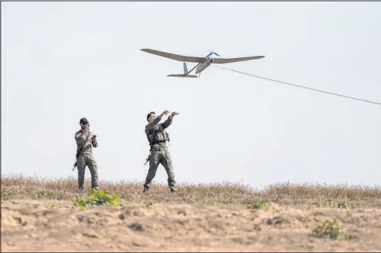  ?? Ohad Zwigenberg The Associated Press ?? Israeli soldiers launch a drone Monday near the Israeli-gaza border. Israel’s defense minister said a meeting among top officials included plans for evacuating civilians and expanding deliveries of food and medical equipment to Gaza.