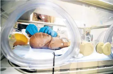 ?? CARLINE JEAN/STAFF PHOTOGRAPH­ER ?? Instructor Gloria Trujillo, with the University of Miami simulation nursing program, practices working on a newborn in the neo-natal intensive care unit. Practition­ers say the trend toward simulated training brings better real-world results on...