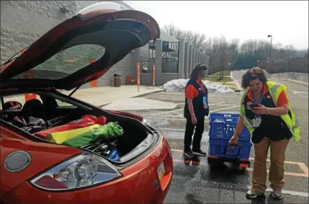  ?? DONNA ROVINS — DIGITAL FIRST MEDIA ?? Bechtelsvi­lle Walmart Associate Jessica Swinehart prepares to deliver a grocery order to a customer on Thursday. Swinehart is taking a final look at the order before loading it into the car. She is assisted by associate Janet Gruber. Three Berks County...