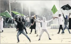  ?? PICTURE: AP/ANA/DAR YASIN ?? Masked Kashmiri protesters wave Pakistani flags during a protest after Eid prayers in Srinagar, in Indian-controlled Kashmir, yesterday. Police said at least one man was killed and over a dozen wounded.