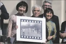  ?? GREGORIO BORGIA ?? PULITZER PRIZE-WINNING PHOTOGRAPH­ER Nick Ut (center) flanked by Kim Phuc (left) holds the” Napalm Girl”, his Pulitzer Prize winning photo as they wait to meet with Pope Francis during the weekly general audience in St. Peter’s Square at The Vatican on Wednesday.