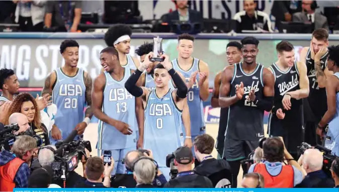  ??  ?? CHARLOTTE: Kyle Kuzma #0 of the US Team receives the MVP award after the 2019 Mtn Dew ICE Rising Stars Game on Friday at the Spectrum Center in Charlotte, North Carolina.— AFP