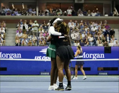  ?? Charles Krupa/Associated Press ?? Venus Williams embraces younger sister Serena Thursday night after they lost in doubles at the U.S. Open. The Wiliams sisters lost to Lucie Hradecká and Linda Nosková.