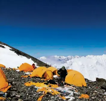  ?? Foto: Dawa S. Sherpa, dpa ?? Das höchste Lager am Mount Everest ist mit Zelten übersät. Ein Räumungste­am beseitigt den Müll.
Touristen ein Depot von 4000 Dollar nutzen. Wenn Menschen auf dem