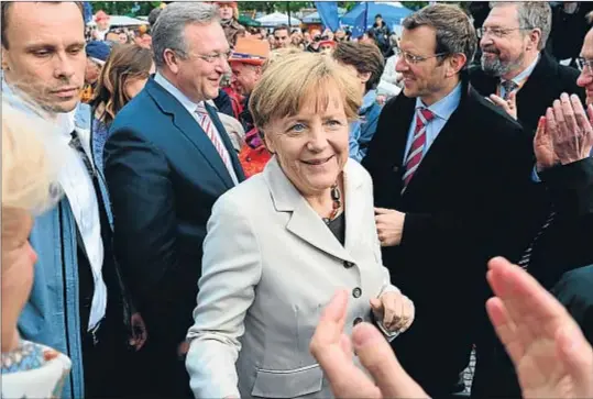  ?? JOHN MACDOUGALL / AFP ?? Angela Merkel llegó a media tarde a la Breitschei­dplatz de Berlín; al empezar su intervenci­ón, arrancó la protesta