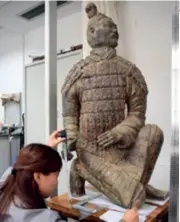  ??  ?? A researcher measures a terracotta warrior statue in Xi’an, Shaanxi Province, on September 1, 2017