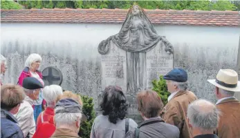  ?? FOTO: PRIVAT ?? Die Besucher erfahren Historisch­es vor dem Grab von Familie Zimmerer auf dem Hedinger Friedhof.