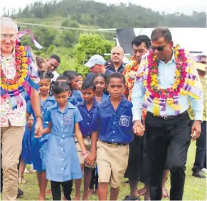  ?? Photo: JOSAIA RALAGO ?? Australian High Commission­er to Fiji, Ewen McDonald, (left) with the Deputy Prime Minister and Minister for Finance, Biman Prasad, while escorting Dreketi Primary School students from the tents to their new classrooms