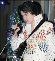 ?? GILLIS BENEDICT — LIVINGSTON COUNTY DAILY PRESS & ARGUS VIA AP ?? Bryson Vines, 13, of Howell performs a set in Elvis fashion in Peanut Row Alley as part of Fantasy of Lights festivitie­s. Friday, Nov. 26, 2021, in Howell. Bryson has been performing as an Elvis tribute artist for several years.