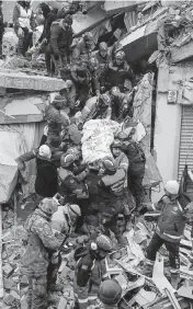  ?? CAN OZER AP ?? Rescue workers in Hatay, Turkey, move a 36-year-old man from a collapsed building five days after the earthquake.