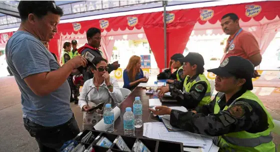  ?? —LYN RILLON ?? SECURITY CHECK Police check documents of people entering Boracay before allowing them through the lanes for workers or residents at Caticlan Jetty Port in Malay town, Aklan province, and passage by boat to the island that is now undergoing...