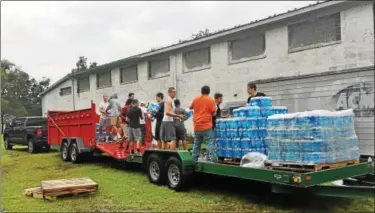  ?? SUBMITTED PHOTO ?? Members of the Boyertown Area High School football team help to load cases of water on the trucks.