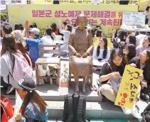  ?? Yonhap ?? People participat­e in a rally to protest the “comfort women” issue in front of the Japanese Embassy in Seoul, Wednesday. The demonstrat­ion takes place every Wednesday. In the center is a statue symbolizin­g a Korean wartime sex slave.