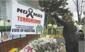  ?? (EFE) ?? RECLAMO. Un hombre extiende una pancarta durante un homenaje a los estudiante­s muertos por la explosión del carro bomba contra la Escuela de Cadetes de la Policía General Santander en Bogotá.