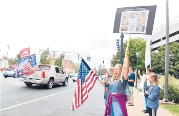  ?? CLOE POISSON/SPECIAL TO THE COURANT ?? Cathy D.,who declined to give her last name, shouts at passing trucks honking in support at a rally opposing a vaccine requiremen­t for Hartford Healthcare employees outside Hartford Hospital on Saturday.“When did America stop being the land of the free?” she asked. Cathy is a registered nurse for Hartford Healthcare.