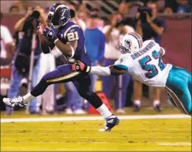  ?? Matt York Associated Press ?? LaDAINIAN TOMLINSON is tackled by Miami’s Morlon Greenwood during the Chargers’ “home” game at Sun Devil Stadium in Tempe, Ariz., on Oct. 27, 2003.