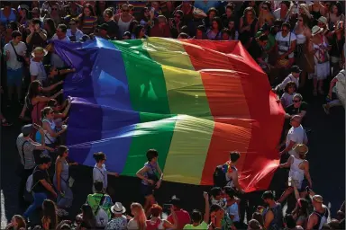  ?? (AP/Manu Fernandez) ?? Participan­ts of the annual LGBTQ pride parade carry the rainbow flag in Madrid, Spain, in July 2019. The Spanish Cabinet on Tuesday approved a draft bill on LGBTQ rights to allow transgende­r people older than 16 to change their genders and names in the official registry without doctors or witnesses intervenin­g.