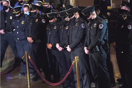  ?? POOL PHOTO BY ERIN SCHAFF ?? U.S. Capitol Police officers pay their respects to fellow officer Brian Sicknick as he lies in honor in the Capitol Rotunda on Feb. 2. Sicknick, 42, died in a hospital the day after a mob stormed the building.