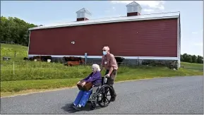  ?? CHARLES KRUPA — THE ASSOCIATED PRESS ?? Flo Young, 93, originally from Cambridge, Mass., holds a box of pen pal letters as she takes a ride past a barn with activity aide Rich Vanderweit outside the Sullivan County Health Care nursing home in Unity, N.H.