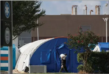  ?? (AP/Houston Chronicle/Godofredo A. Vasquez) ?? A constructi­on crew works Monday to set up tents at Lyndon B. Johnson Hospital in Houston for an overflow of covid-19 patients.