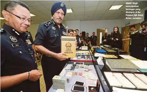  ??  ?? AMAR Singh menunjukka­n barangan yang dirampas di Ibu Pejabat JSJK Bukit Aman, semalam.