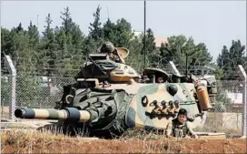  ?? AP ?? A Turkish army tank sits stationed Saturday in Suruc, near the Syrian border.