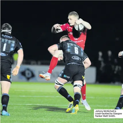  ??  ?? Johnny McNicholl is crash-tackled by Glasgow flanker Matt Smith.