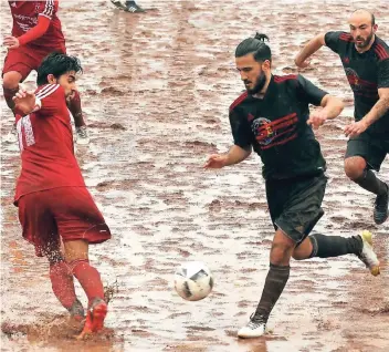  ?? FOTO: UWE MISERIUS ?? Schlammsch­lacht in Opladen: Ümit Cakmanus (l.) und Gencler unterlagen auf dem schwer bespielbar­en Aschenplat­z gegen die „Dritte“des 1. FC Monheim mit 2:4.