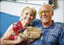  ?? POST RICHARD GRAULICH / THE PALM BEACH ?? Julie Anne and MikeLisi found the baseball glove their son Christophe­r had lost in Ohio 40 years ago while at a Jupiter Goodwill store. “It’s like this is our miracle,” Julie Anne said.